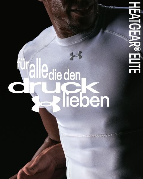 Ein Mann, der ein weißes Under Armour Hemd trägt, steht vor einem dunklen Hintergrund mit deutschem Text und "HEATGEAR® ELITE" an der Seite.
